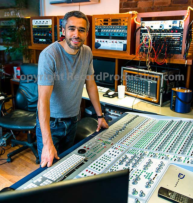mike cave by his mixing board in the recording studio